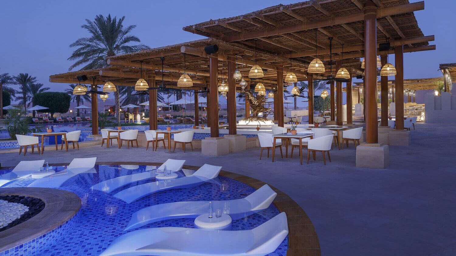 Beleuchtete Poolbar am Abend.