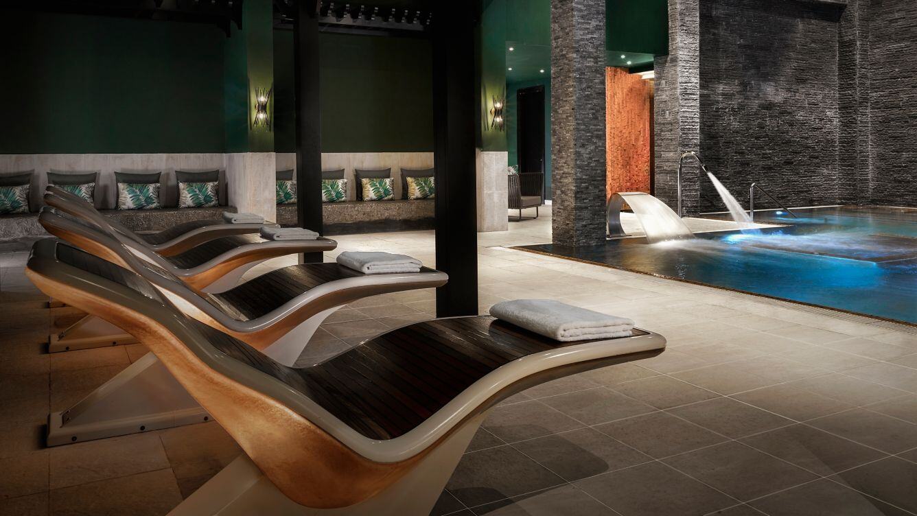 Hochmoderner Spa-Bereich mit Liegen und Pool.