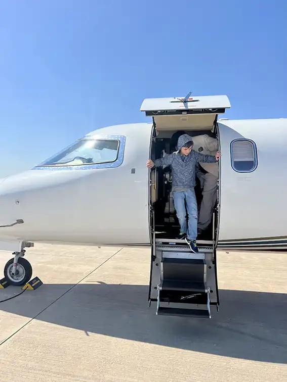 Ein Junge steigt aus einem Privatjet