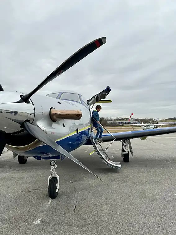 Ein kleiner Junge steigt aus einem Privatjet aus.