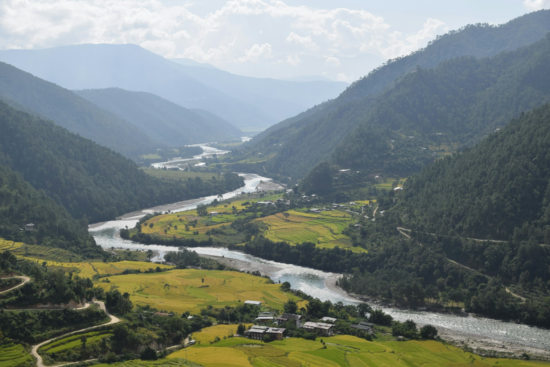 Eine grüne Landschaft, durch die sich ein Fluss zieht.