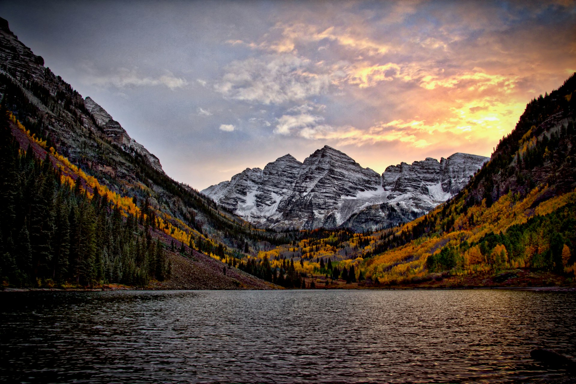 Im Vordergrund ein See, im Hintergrund eine bewaldete Berglandschaft