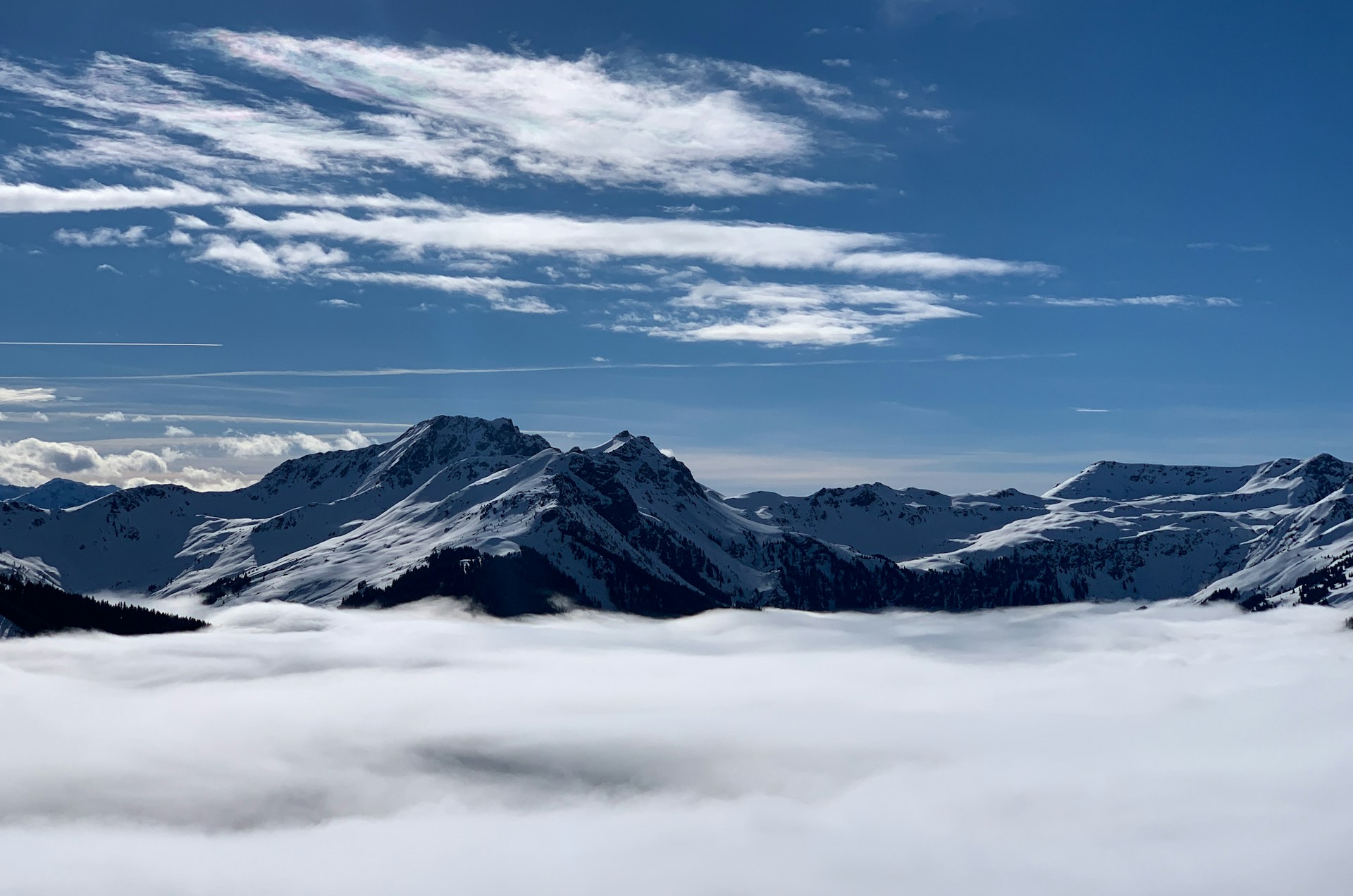 Eine verschneite Berglandschaft über den Wolken