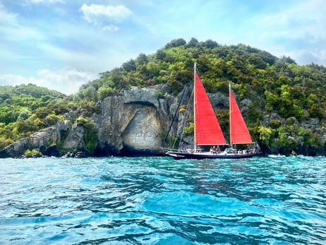 Ein Boot vor einem Felsen mit traditionellem Kunstwerk