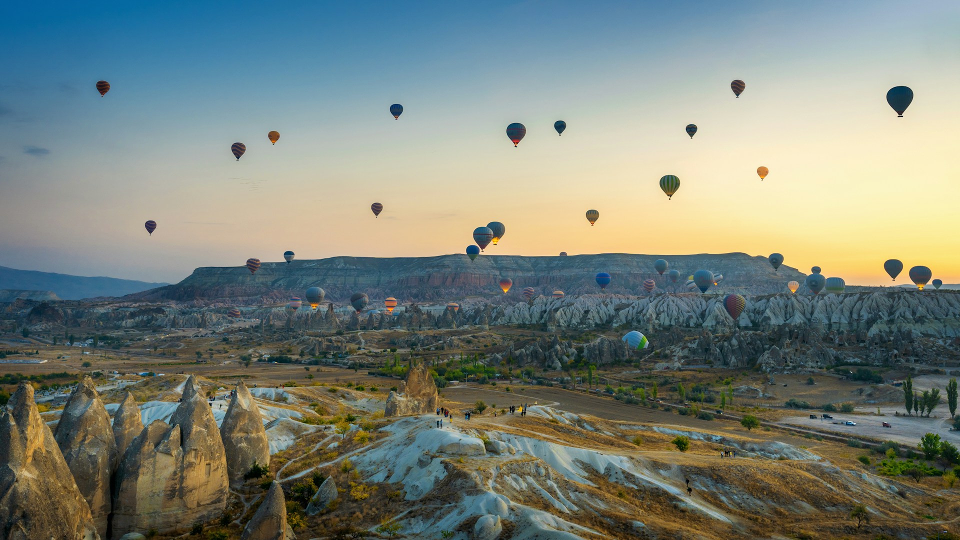 Heißluftballone fliegen über Felsenlandschaft