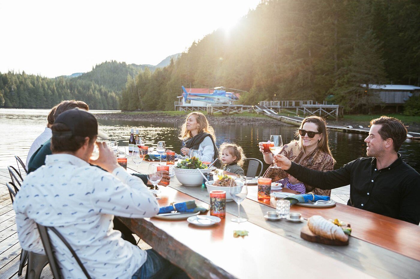 Eine Familie sitzt gemeinsam beim Essen in einer Lodge in British Columbia.